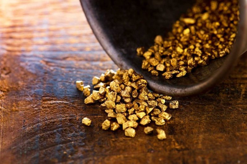 gold-nuggets-spilling-from-a-container-onto-a-wooden-surface-68XNMF-800×533-1